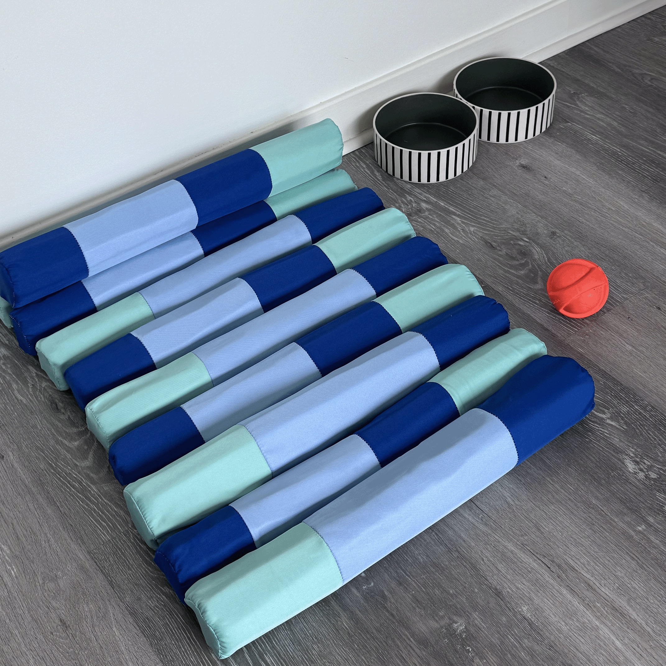 Overhead view of the bed beside two bowls and a ball